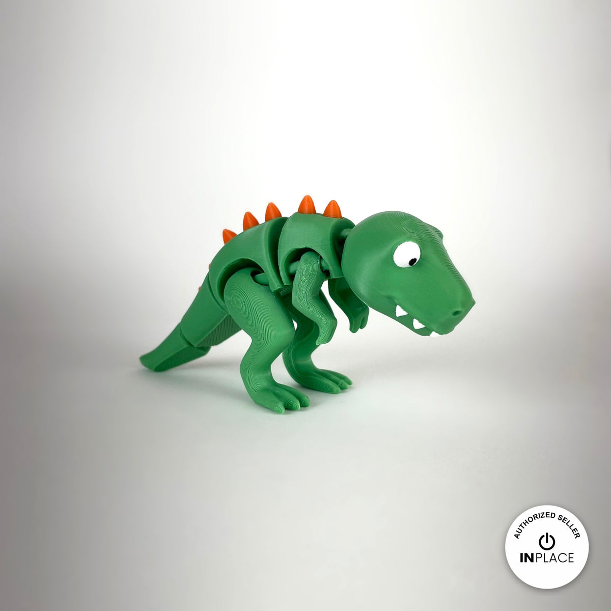 Cute T Rex dinosaur keychain, 3D printed by RU3D – three quarter view facing right. Green with orange spikes.