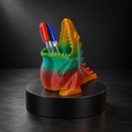 Dinosaur pen holder printed in rainbow glitter filament with colourful pens inside.