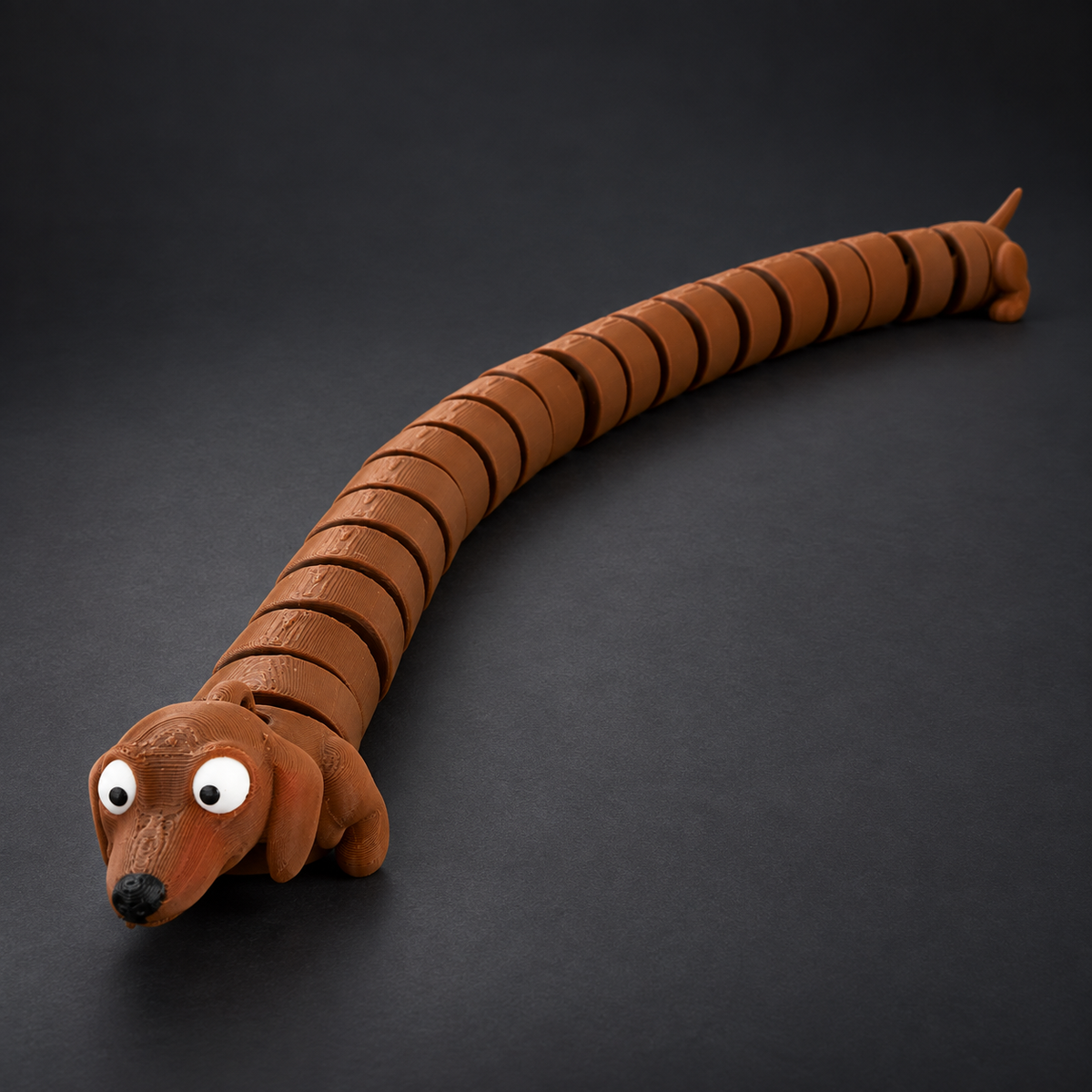 Extra Long Flexi Dachshund with exaggerated articulated body displayed on a dark charcoal studio background.