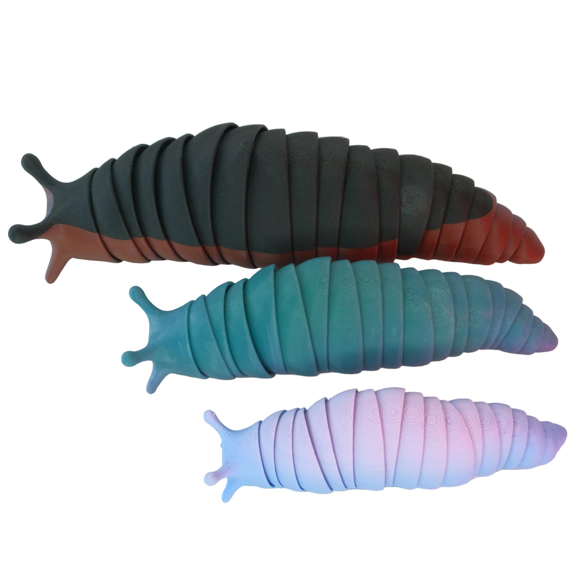 A set of three soft, slug-shaped toys in varying colors, including black, teal, and pink, with segmented bodies that can be flexed. Each slug is smooth and rounded.