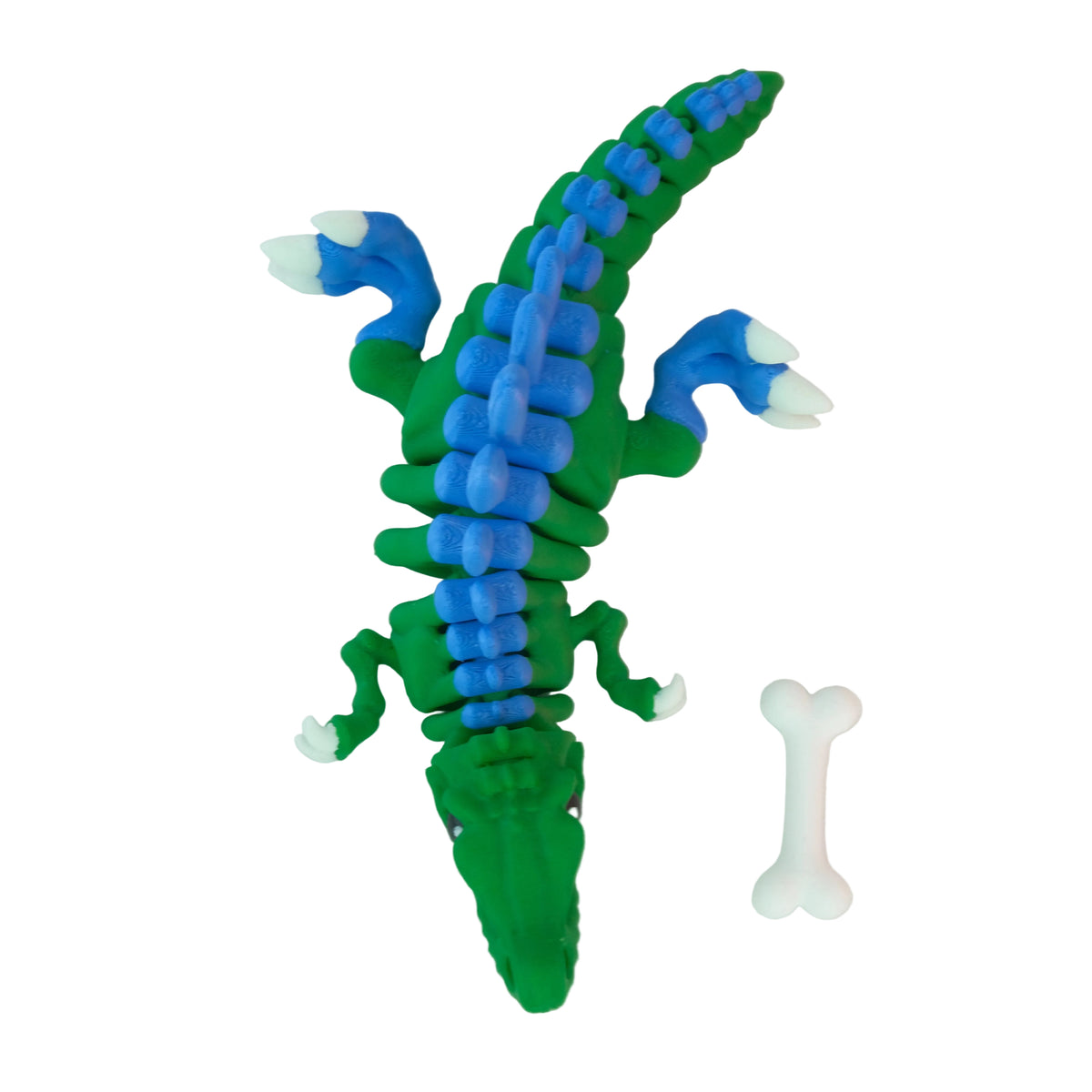 A green articulated crocodile figure with blue accents, featuring white claws and a white bone nearby.