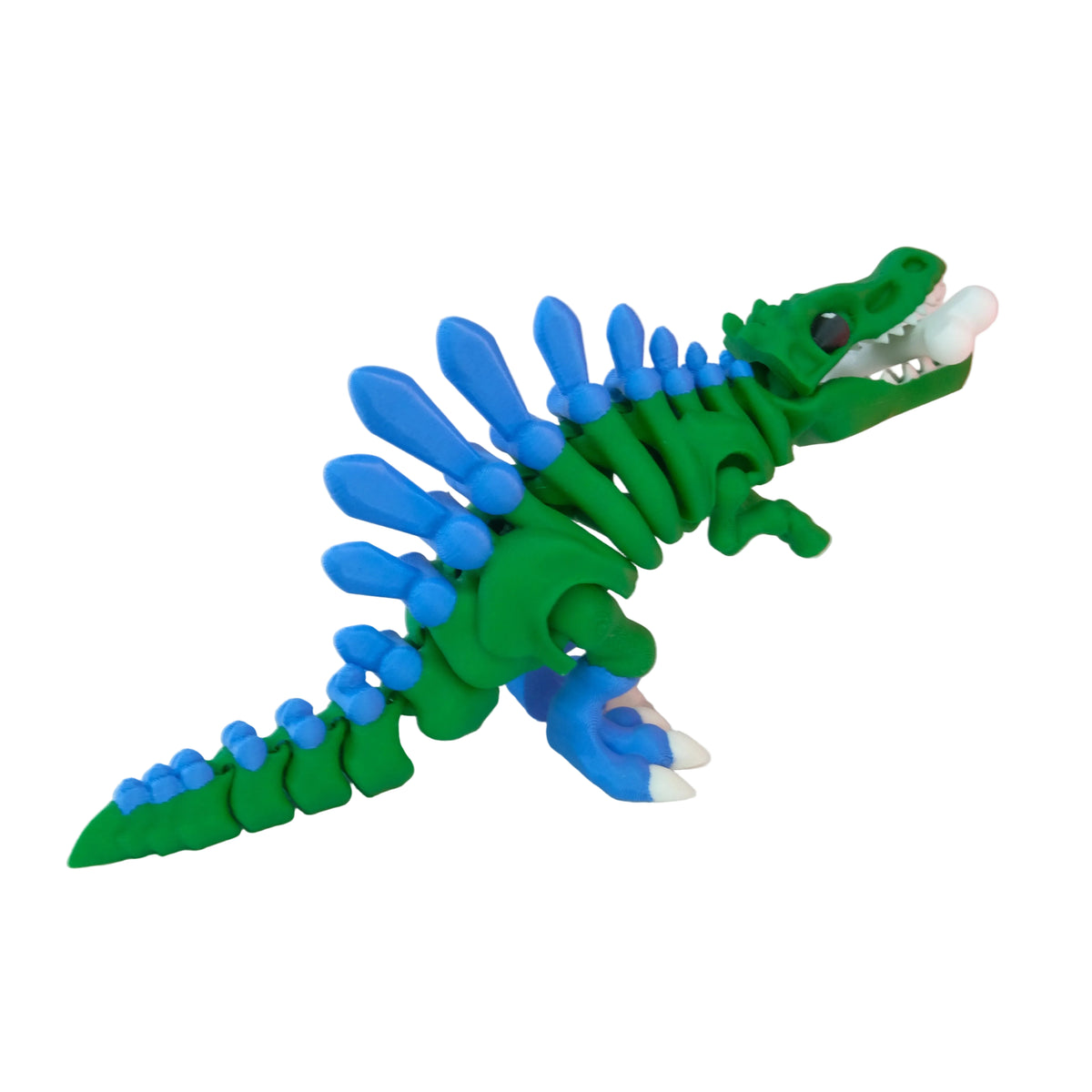 A toy dinosaur colored in green and blue, featuring articulated joints and a dragon-like appearance with spines along its back.