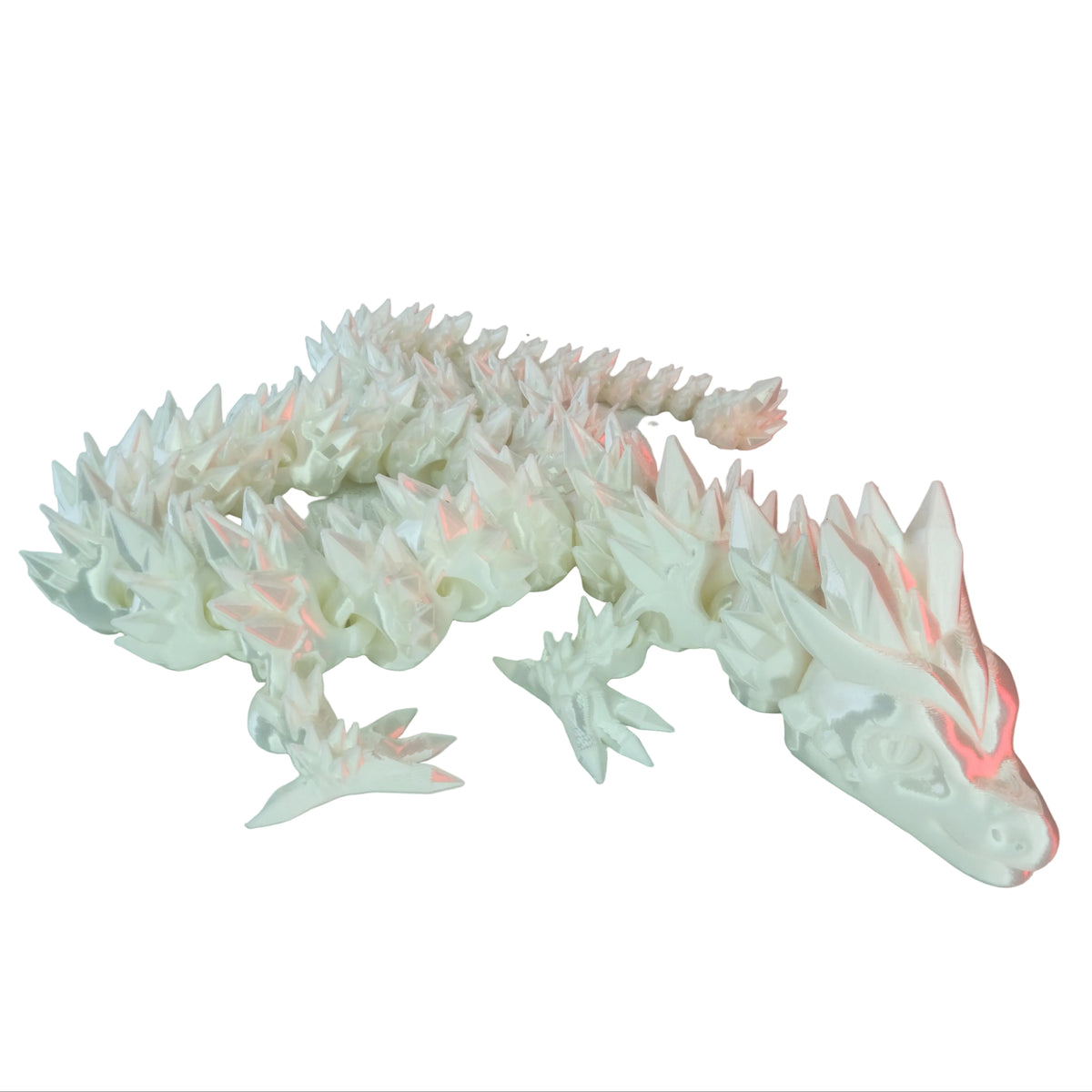 A white ornate dragon figurine with intricate spines and articulated joints, lying flat against a white background.