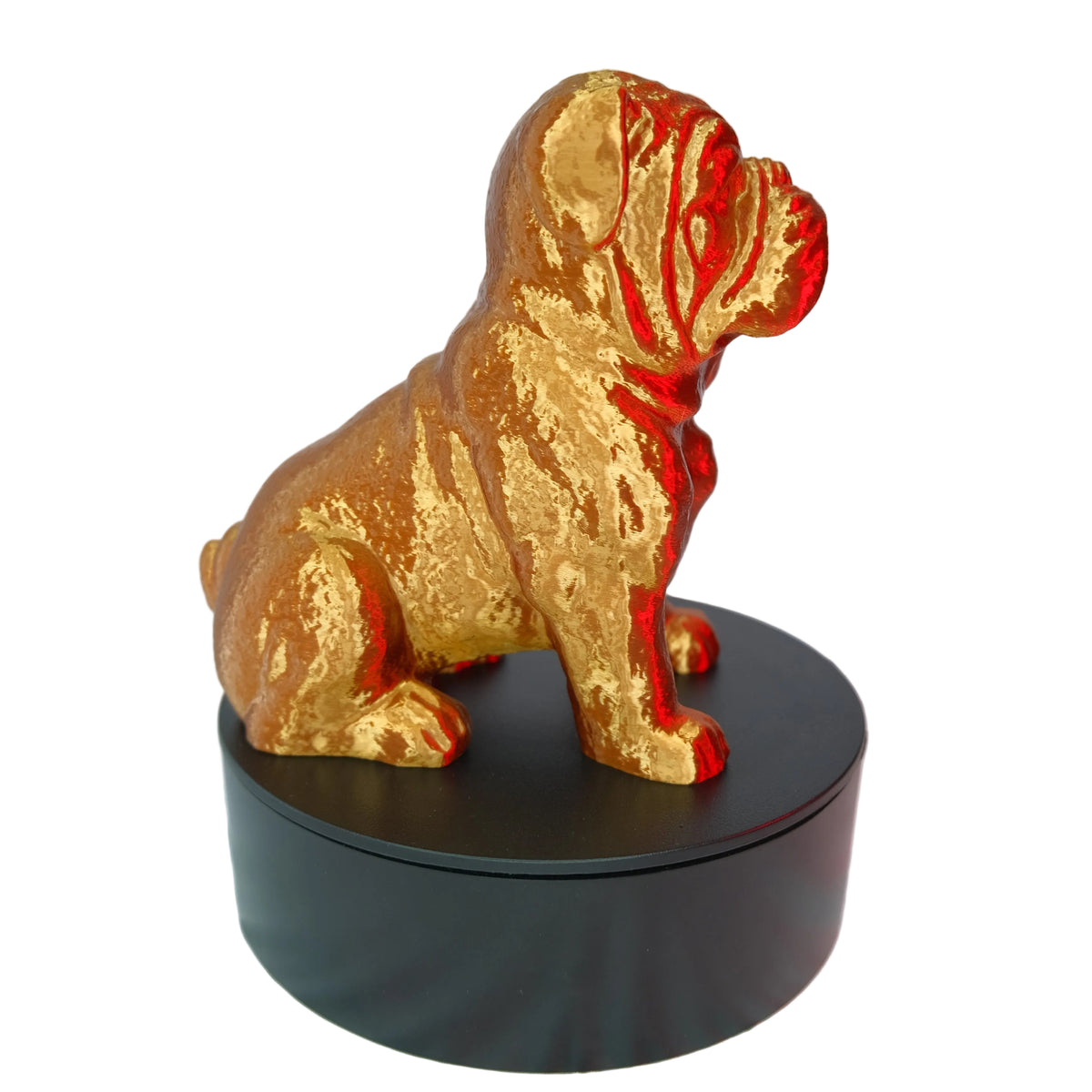 A glossy yellow figurine of a bulldog with intricate details, resting on a circular black display base.