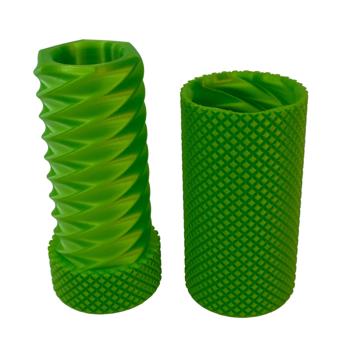 Two green cylindrical objects with textured surfaces, one featuring a spiral design and the other with a diamond pattern.