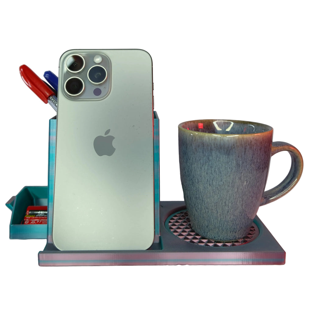 A grey phone stand holding a smartphone next to a coffee cup and pens.