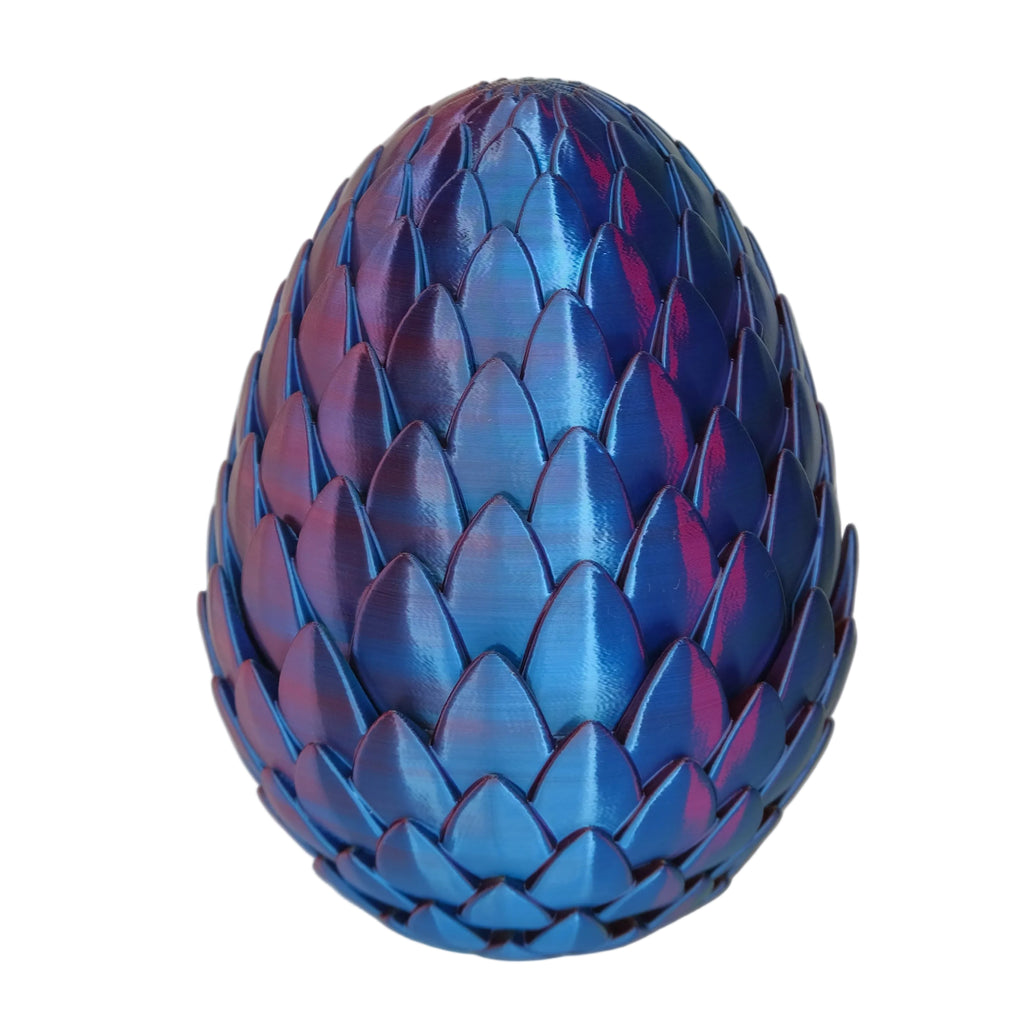 An ornate egg-shaped ornament with a glossy blue finish and a textured, layered surface resembling scales.