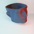A blue novelty planter shaped like a human head, featuring a smooth surface and open top for planting.