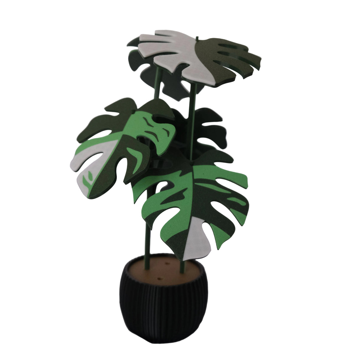 A decorative planter featuring three lush, green monstera leaves in varying shades, mounted on slender stems, with a black round base.