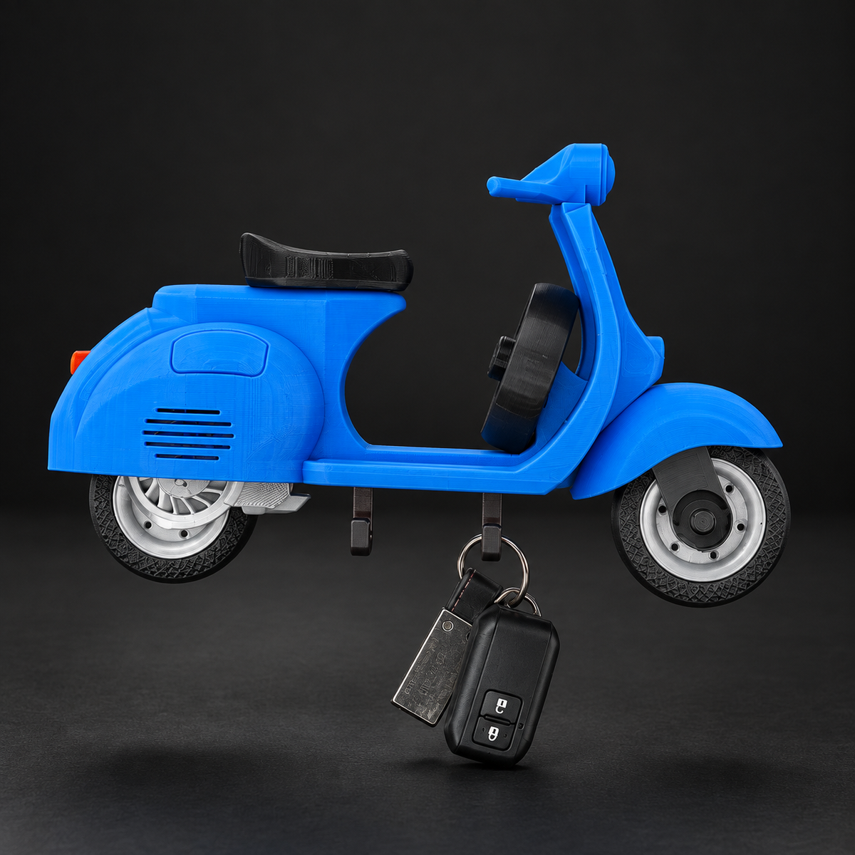 Blue Vespa-style wall key holder with two hooks for keys.